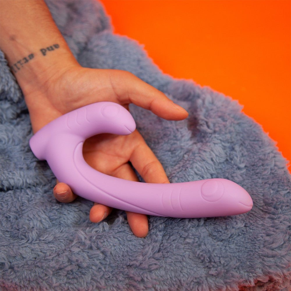 Jix rabbit-style vibrator resting in a person’s hand on a fluffy blue blanket.