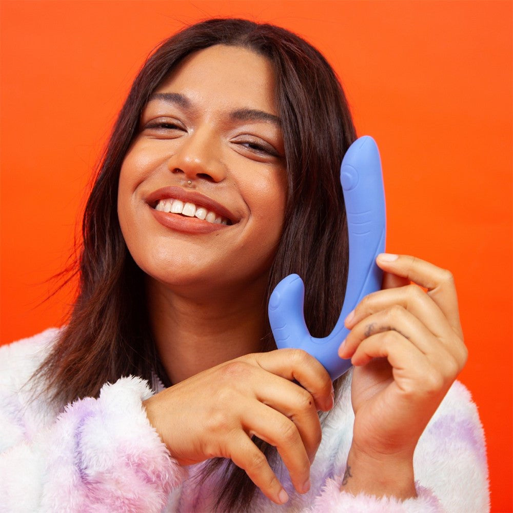 Smiling person holding the Jix vibrator near their face, celebrating pleasure and joy with Cute Little Fuckers.