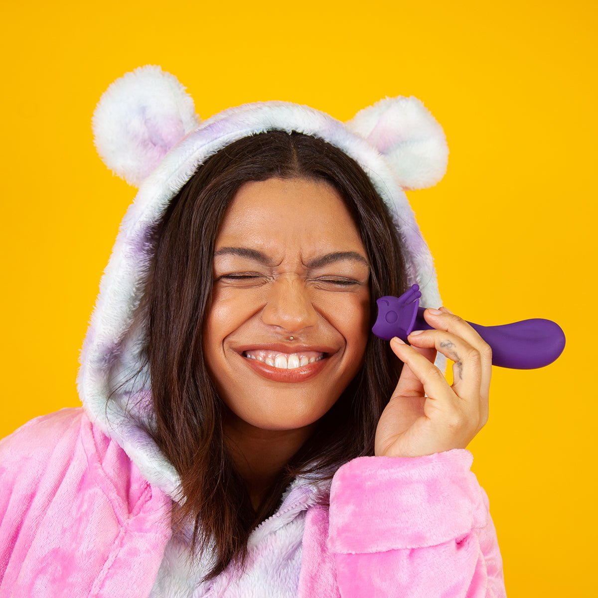 Person smiling while holding the Shimmer vibrator in Midnight. Gender-inclusive, ergonomic sex toy for G-spot or P-spot pleasure.