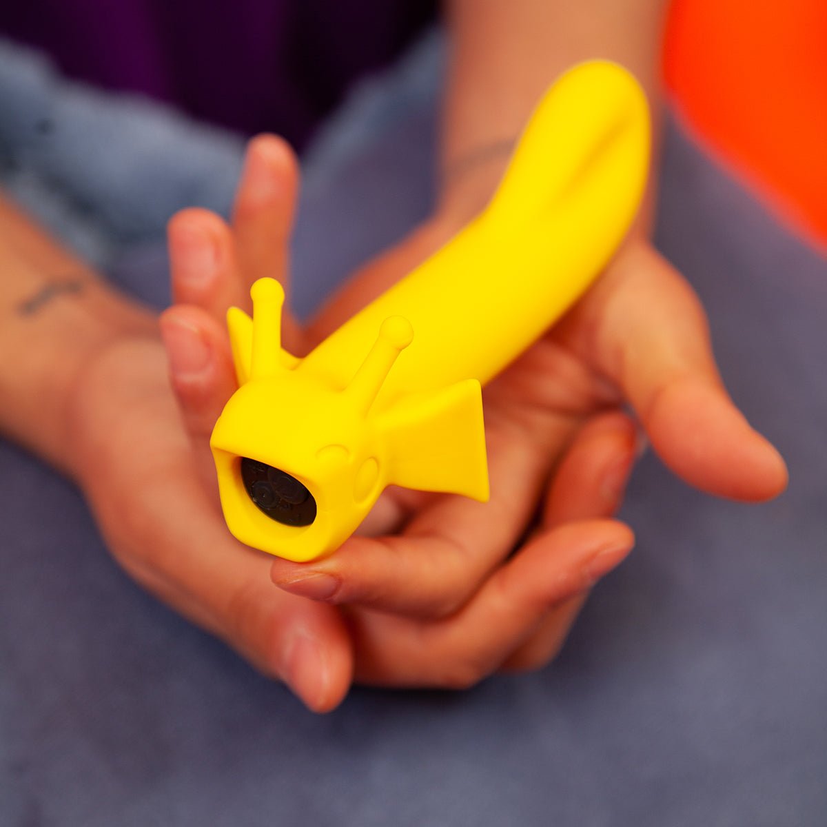 Shimmer vibrator in Sunshine color being gently cradled in two hands. Soft silicone, ergonomic design, and great for new users at SugarX.