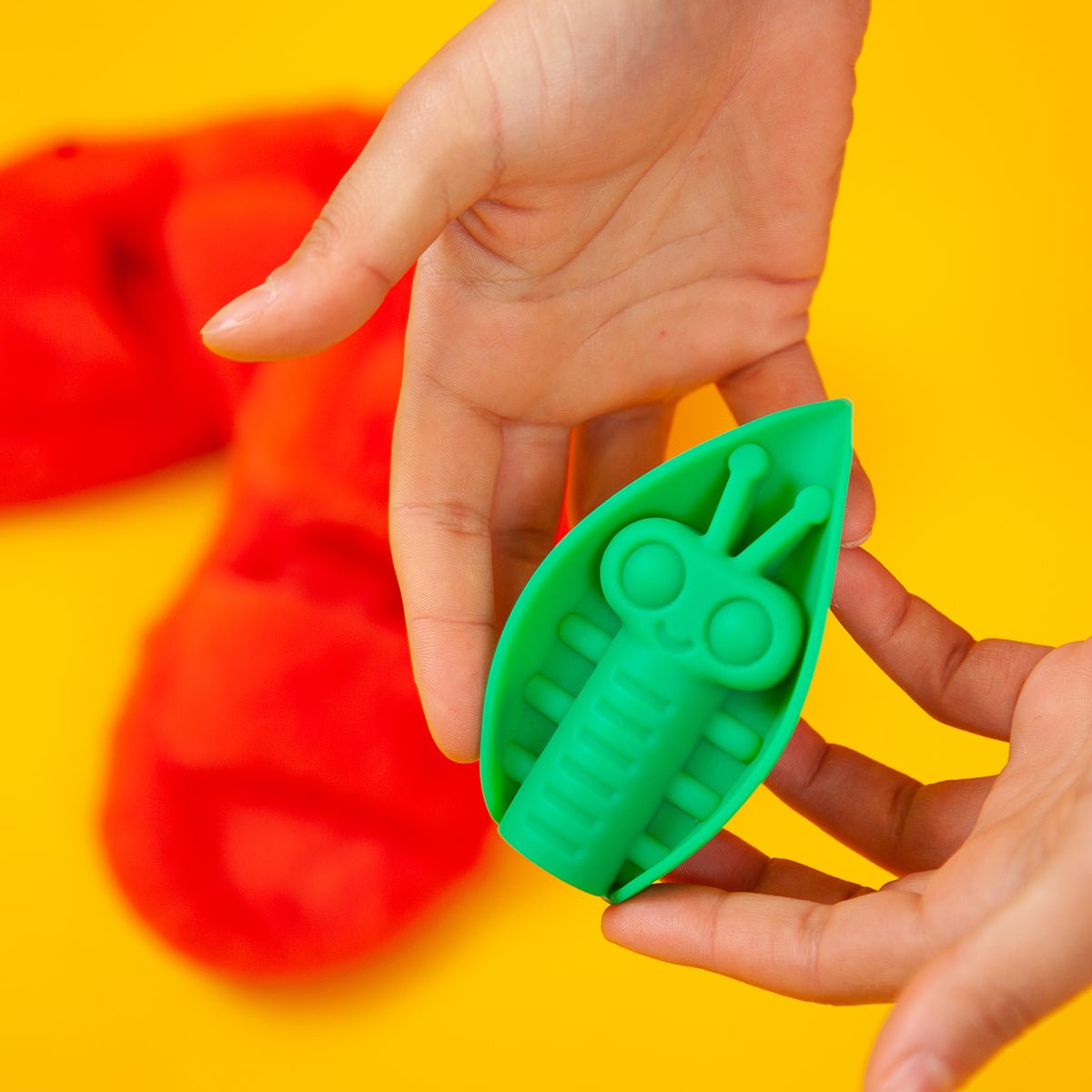 Close-up of the Emerald Zeep vibrator being held, highlighting its smooth silicone texture and ergonomic leaf shape