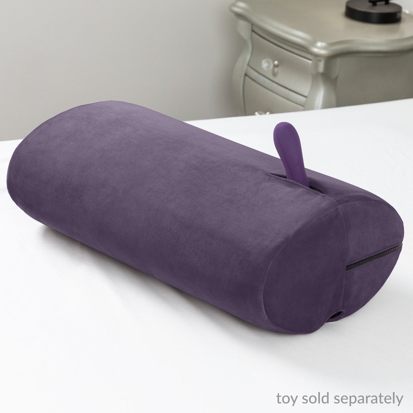The versatile Aubergine Liberator Wing sex toy mount resting on a bed, showcasing its stylish design for hands-free use, available at SugarX.