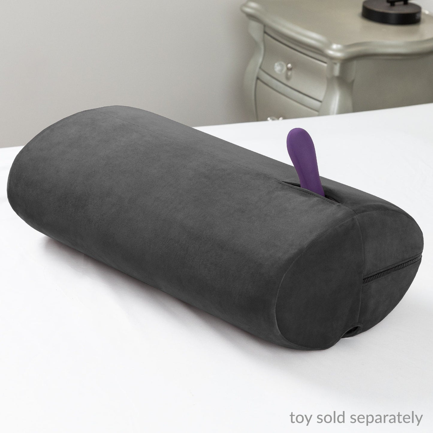 The Black Liberator Wing sex toy mount resting on a bed, highlighting its smooth design for hands-free play, from SugarX.