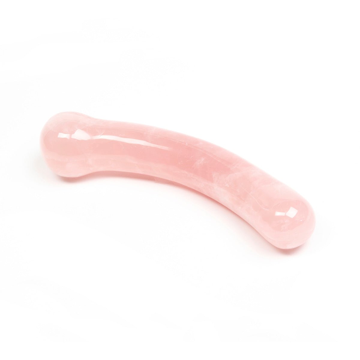 The Heart Curve Non-Realistic by Chakrubs, a non-phallic rose quartz crystal dildo laying on a white background. Available at SugarX in Sex Toys in the Dildo collection.
