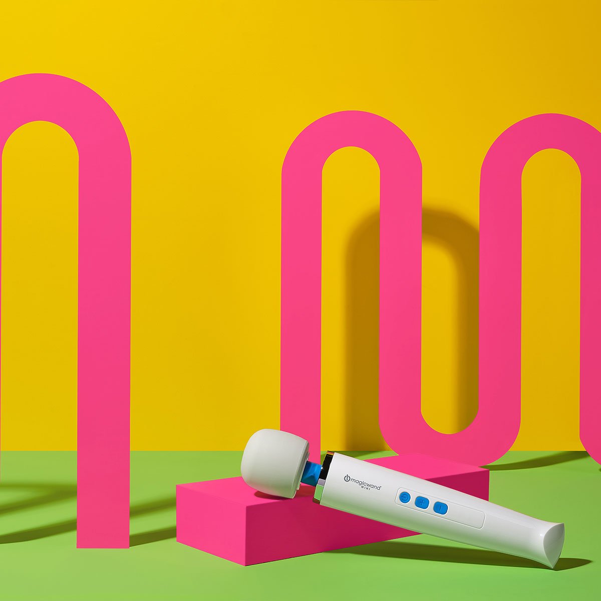 Magic Wand Mini Rechargeable vibrating wand sex toy inclined on a colorful background. Available at SugarX in the Vibrating Wand section of the Sex Toy collection.