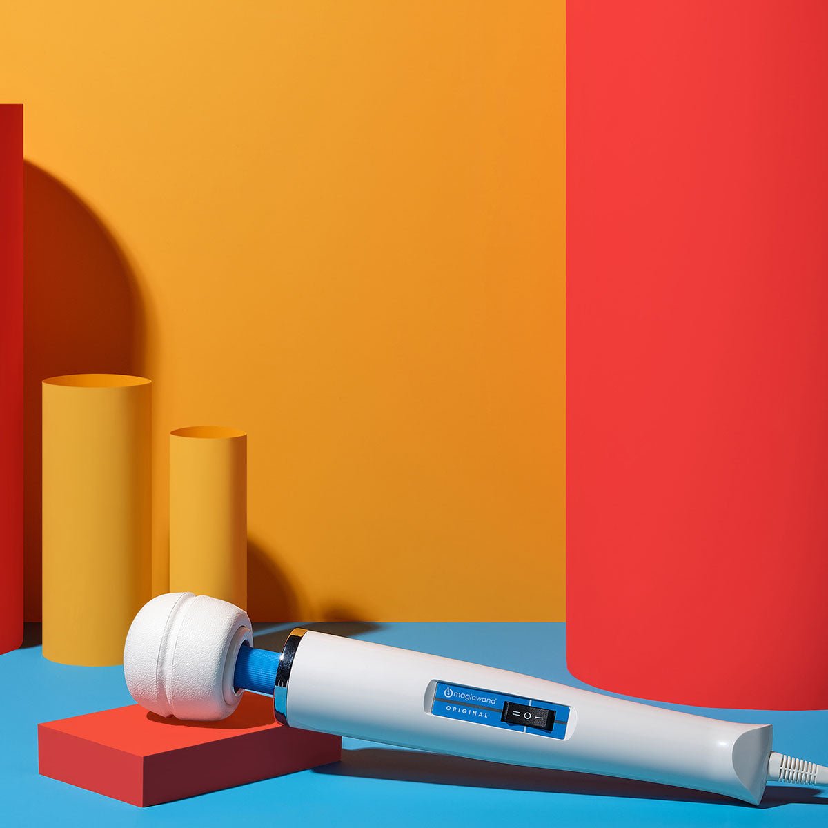 Magic Wand Original Vibrating Wand lying inclined on a colorful background. Available at SugarX in the Vibrating Wand section of the Sex Toy collection.