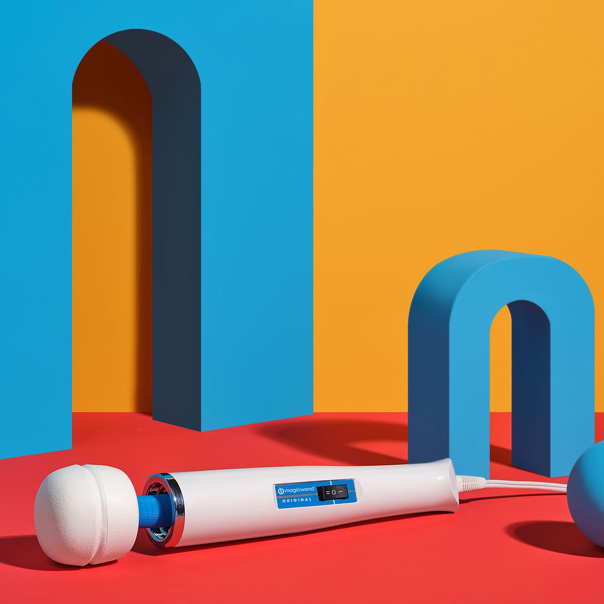 Magic Wand Original Vibrating Wand lying horizontally on a colorful background. Available at SugarX in the Vibrating Wand section of the Sex Toy collection.