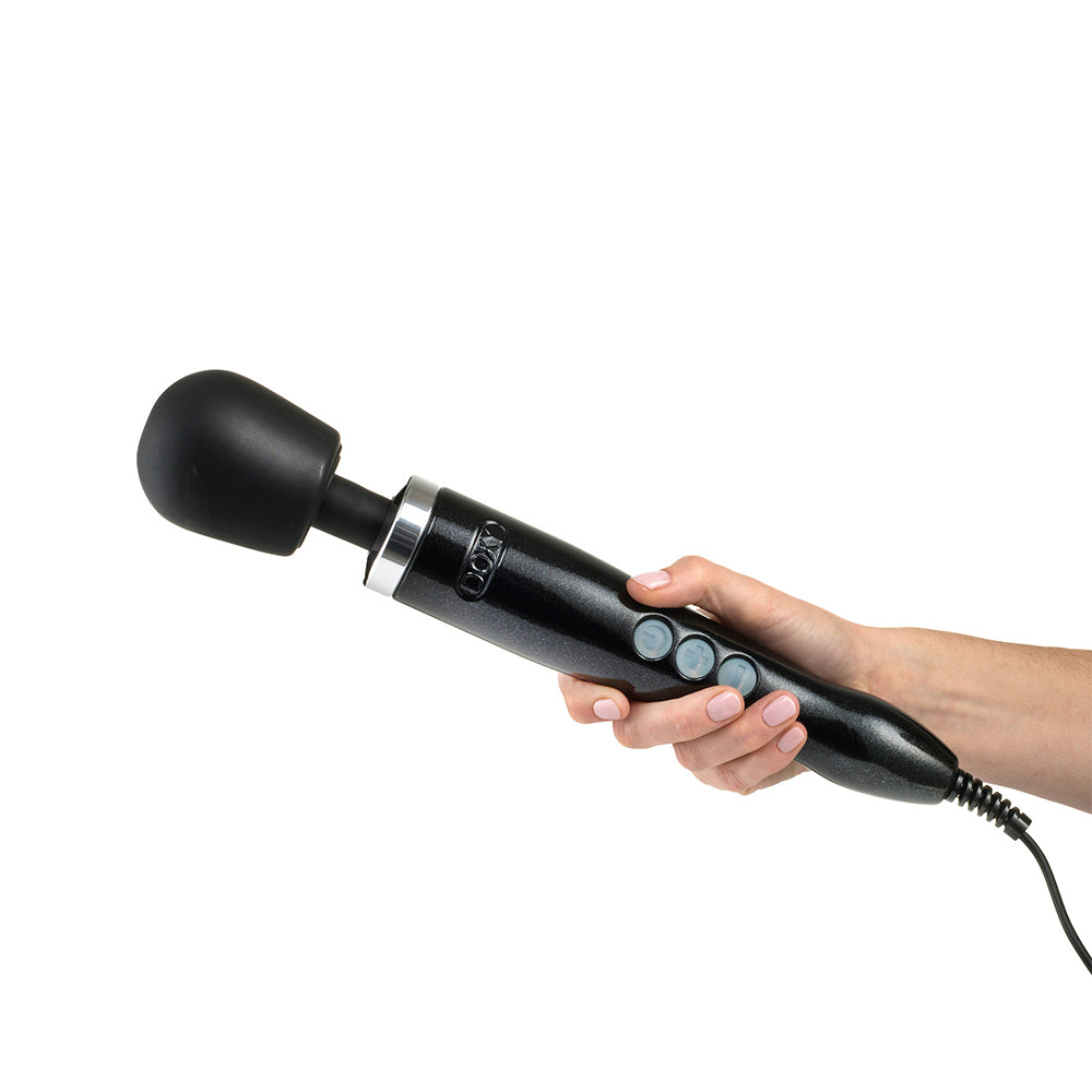 Doxy Die Cast Black wand vibrator being held by a hand, displaying its ergonomic shape and easy control buttons. Available at SugarX in the Vibrators Collection.