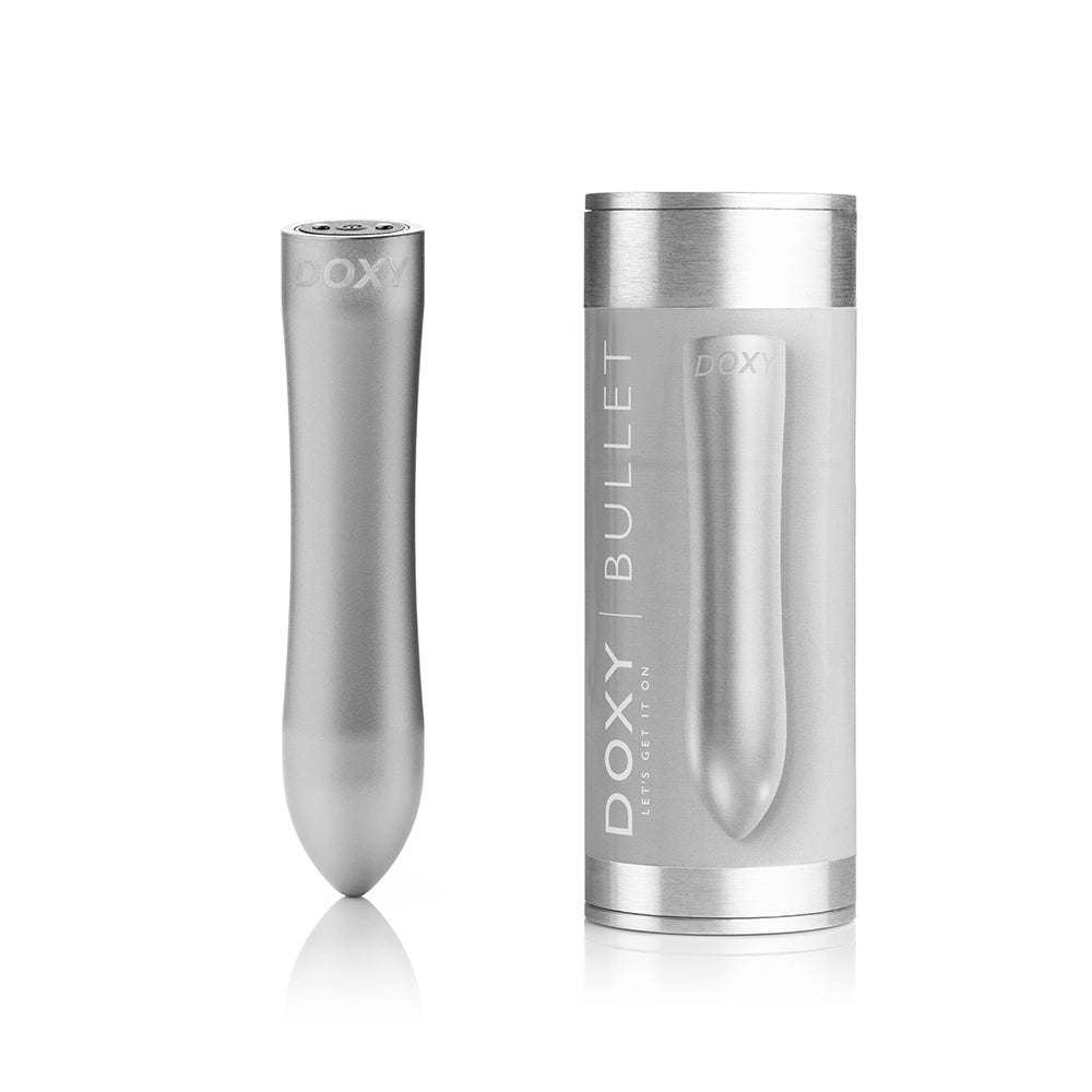 Doxy Bullet vibrator in silver and its box upright facing forward on a plain white background, showcasing the elegant packaging and powerful sex toy within. Available at SugarX in the Vibrators Collection.