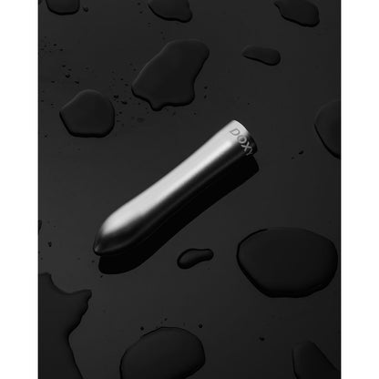 Doxy Bullet vibrator in silver lying diagonally on a black background, accentuating its luxurious rose gold finish and compact design for portability. Available at SugarX in the Vibrators Collection.