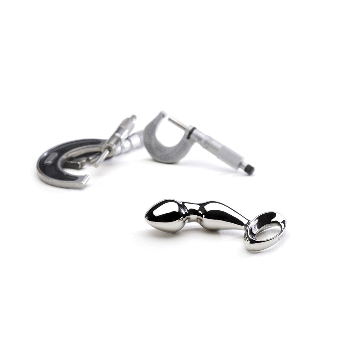 Njoy Pfun Plug shown next to d-rings for size comparison of stainless steel butt plug at SugarX.