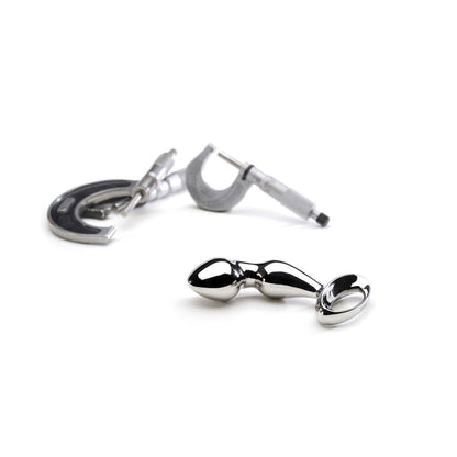 Njoy Pfun Plug shown next to d-rings for size comparison of stainless steel butt plug at SugarX.