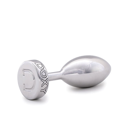 Doxy Smooth Metal Butt Plug standing lying on its side on a plain white background showcasing its tapered aluminum body and extra long stem. Available at SugarX in the Butt Plug section of the Sex Toys collection. 