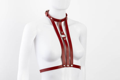 Liberator Lano Leather Chest Harness with adjustable straps, nickel-plated accents, and center O-ring for BDSM restraint and bondage play. Red, angled view.