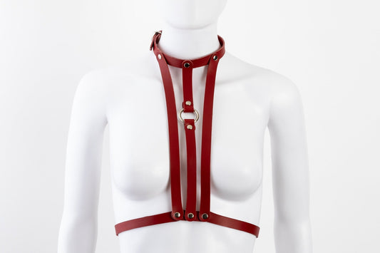 Liberator Lano Leather Chest Harness with adjustable straps, nickel-plated accents, and center O-ring for BDSM restraint and bondage play. Red front view.