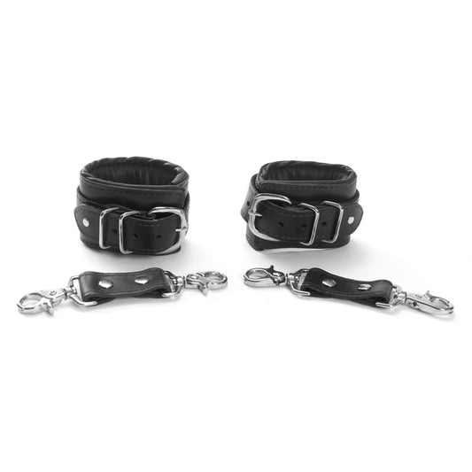 Black Mercer Padded Leather Wrist Cuffs with black lining, worn in a minimalist bondage setting, highlighting sleek design and comfort at SugarX.