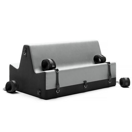 Liberator Steed Spanking Bench in charcoal color displayed alone on a plain white background, accompanied by included cuffs, showcasing its design for BDSM and impact play at SugarX.